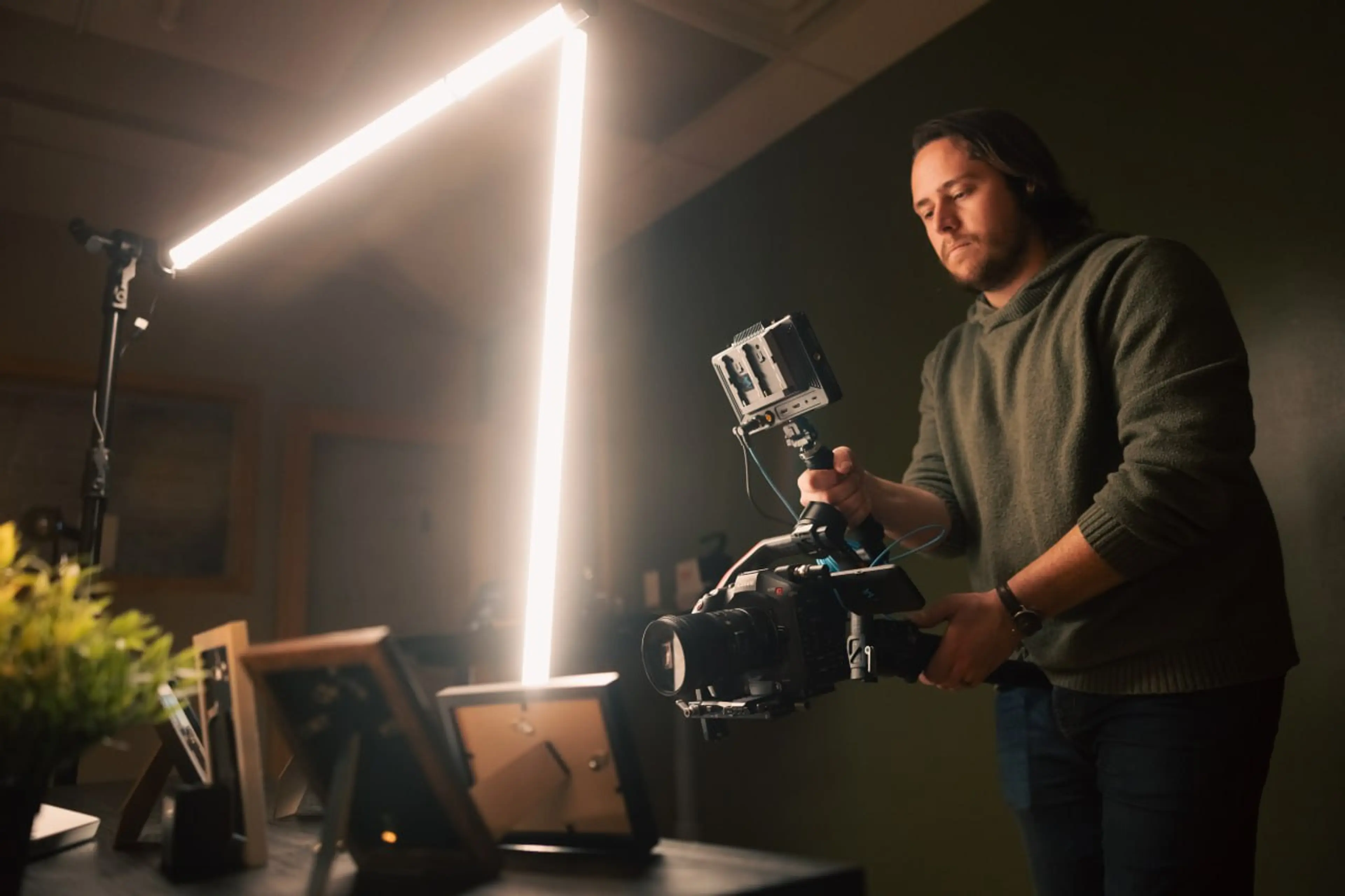 Cinematographer operating a cinema camera rig with LED lighting