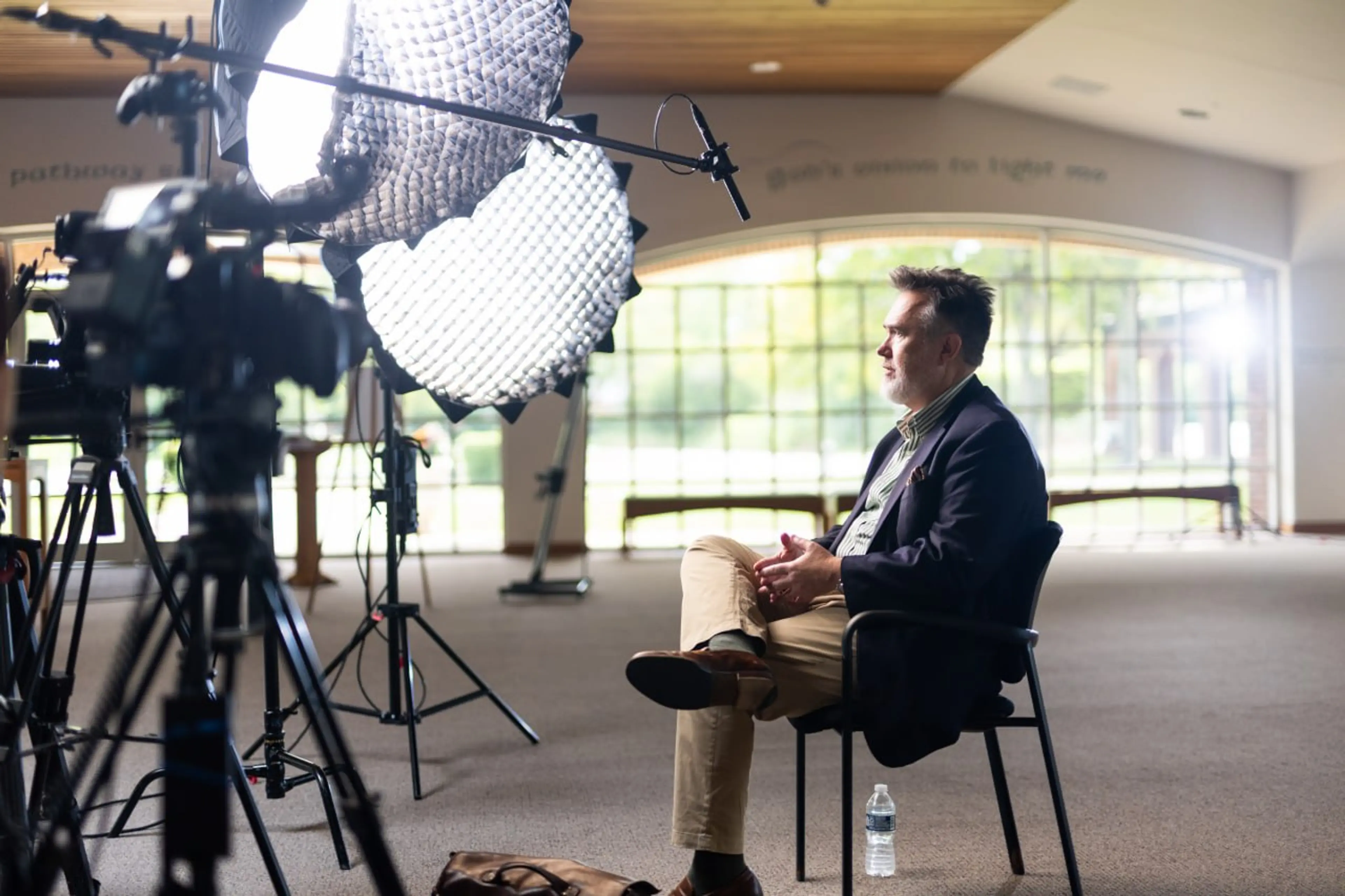 Documentary interview in a chapel with softbox lighting and boom mic