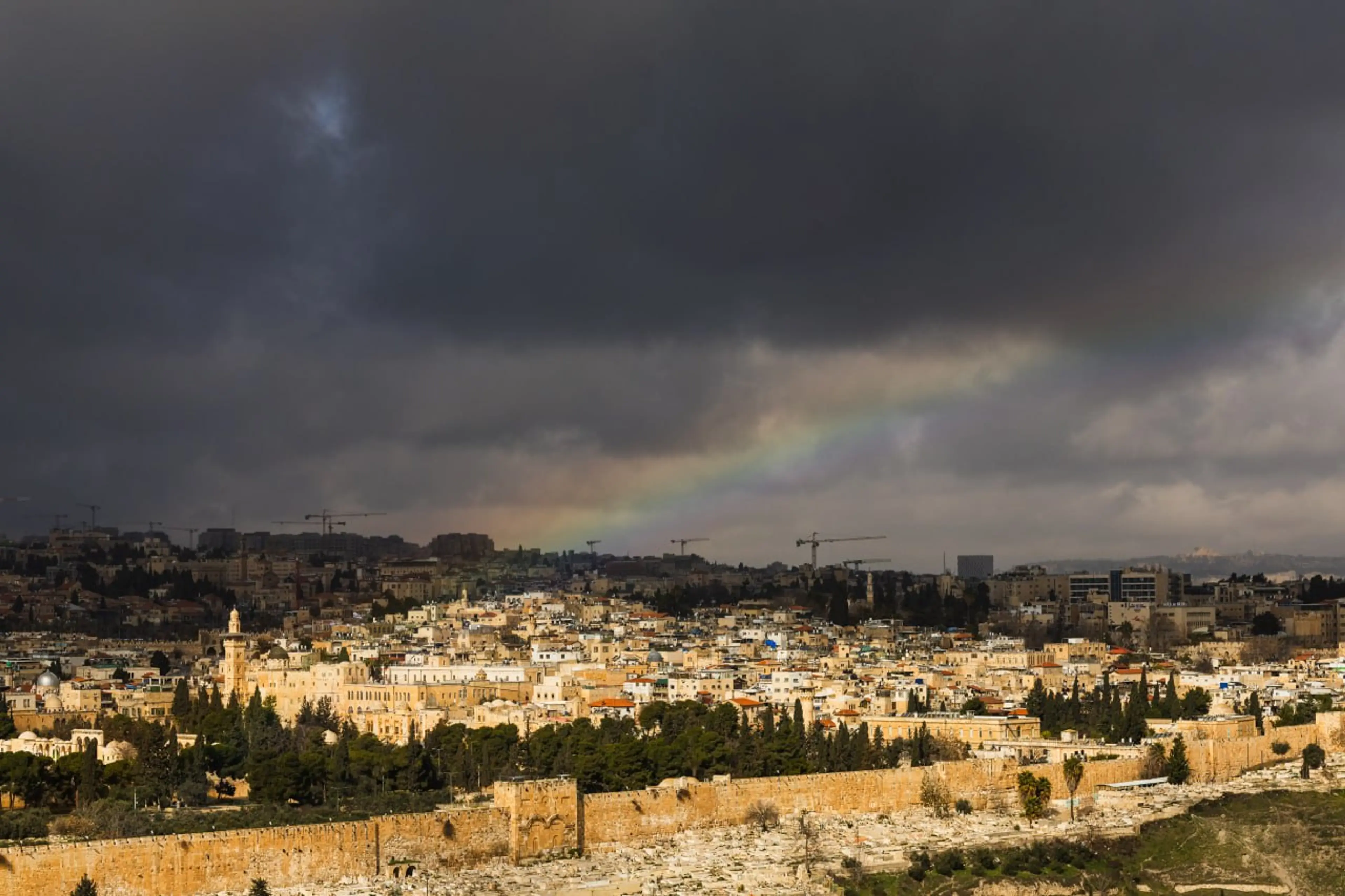 Jerusalem skyline with storm clouds and rainbow over the ancient city walls