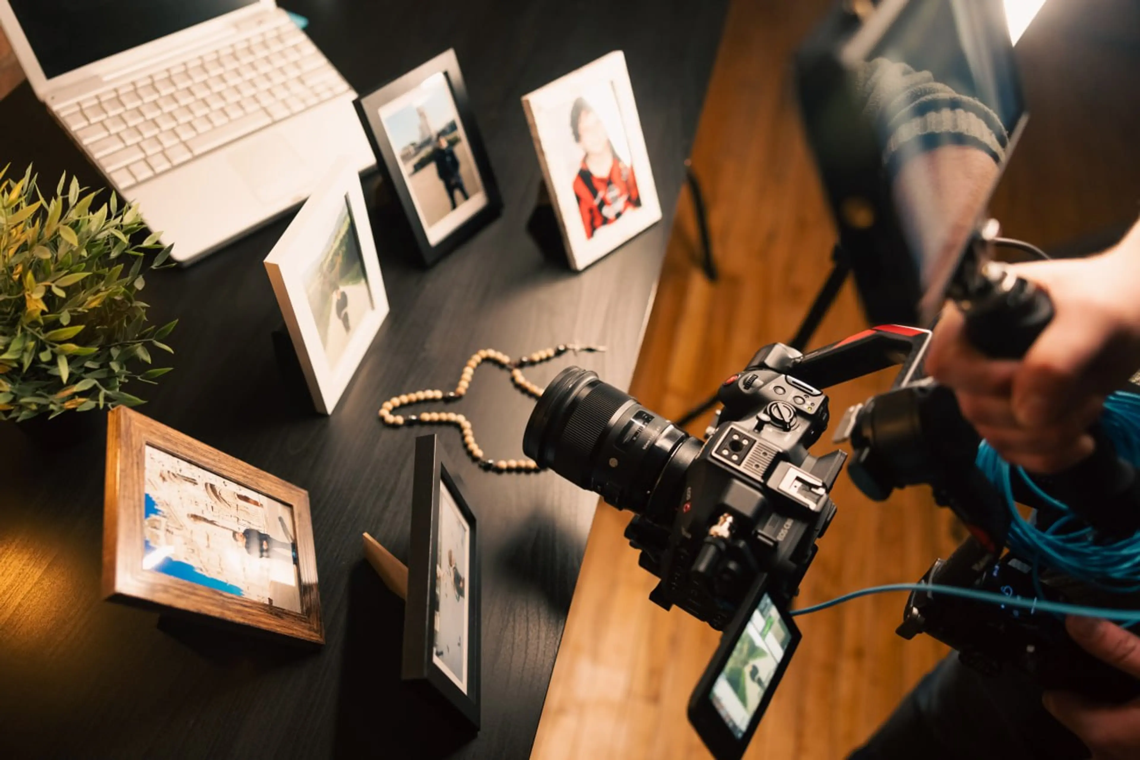 Overhead view of a filmmaker composing a shot of rosary and personal mementos on a desk